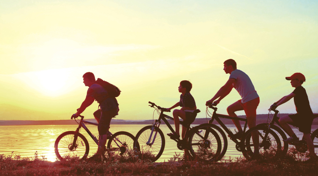 Family on bikes at sunset